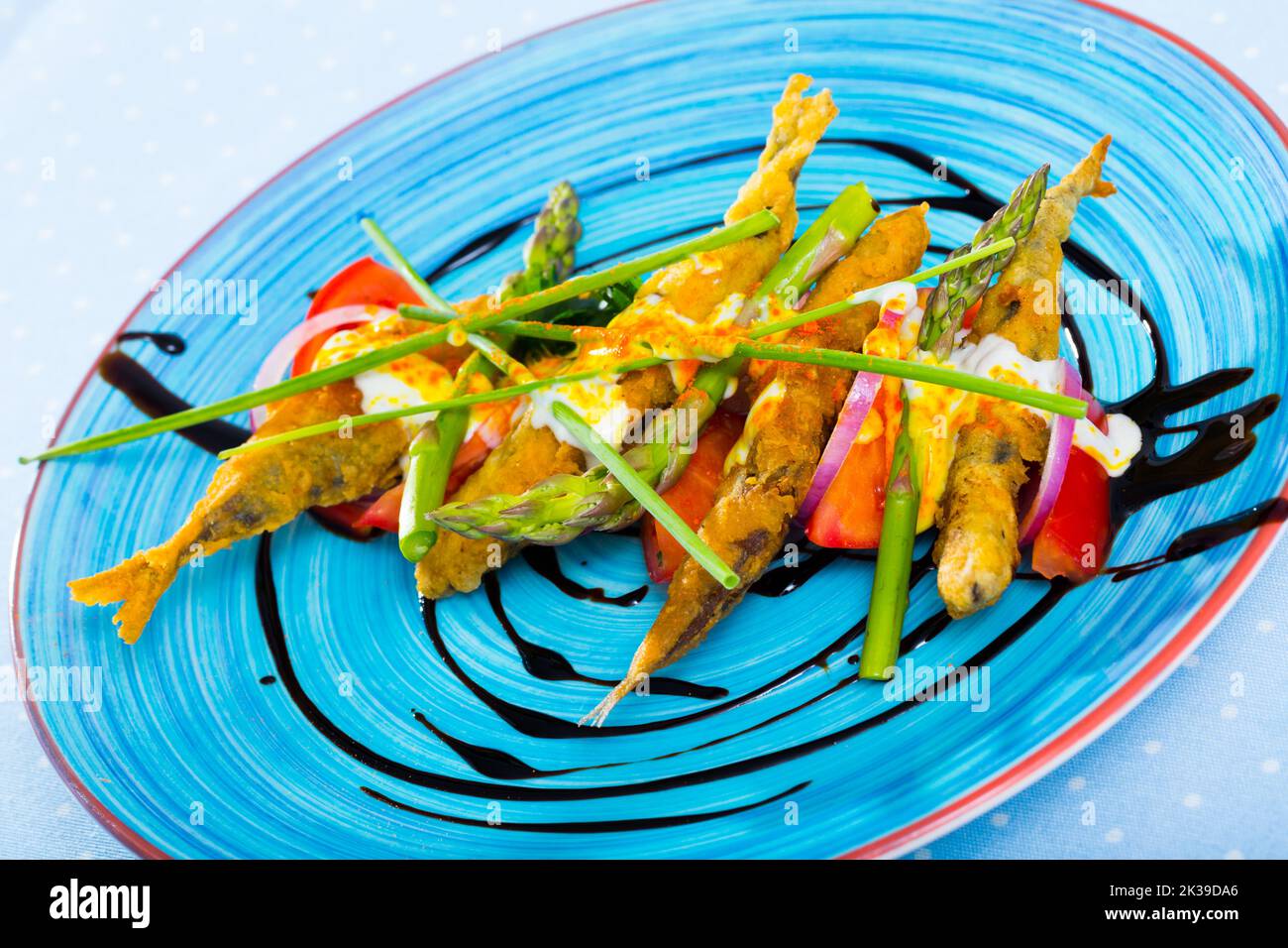 Acciughe in pastella con salsa e verdure Foto Stock