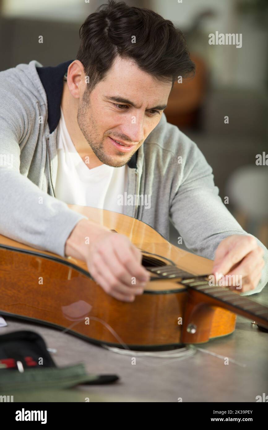 luthier cambia le corde di una chitarra acustica Foto stock - Alamy