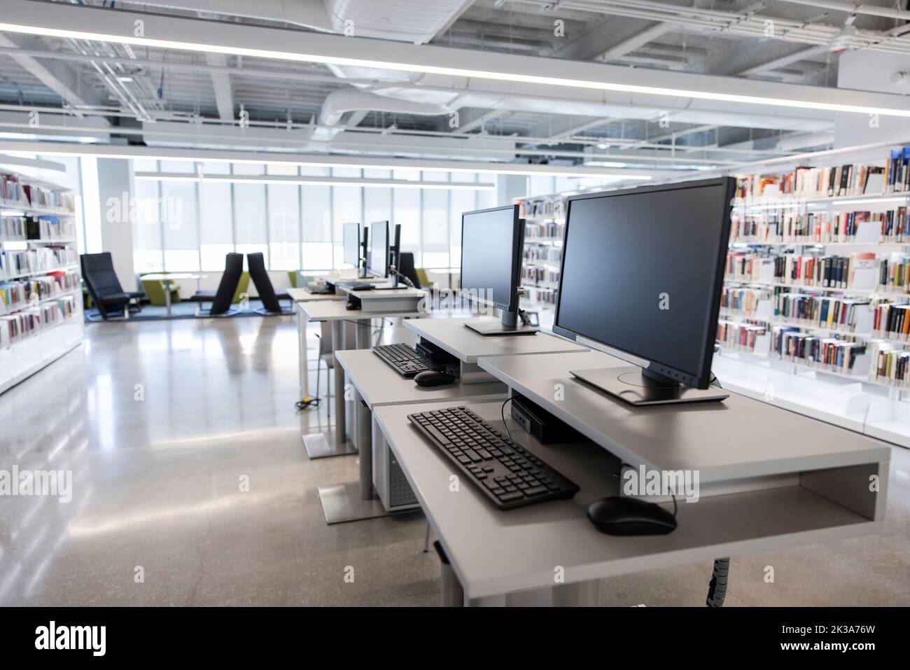 Computer e tastiere in una biblioteca universitaria vuota Foto Stock