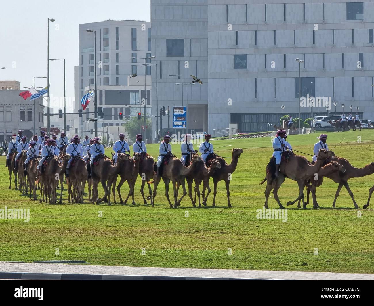 Polizia a dorso di cammello in abiti tradizionali a Doha, Qatar. Doha ha una squadra di polizia unica che indossa il costume tradizionale arabo. Foto Stock