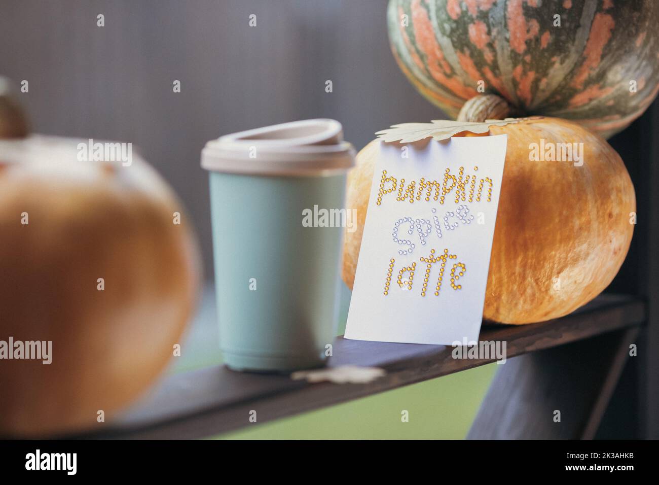 Caffè autunnale in una tazza con zucche e foglie di quercia, sullo sfondo della frase da rhinestones zucca spezia latte. Foto di alta qualità Foto Stock