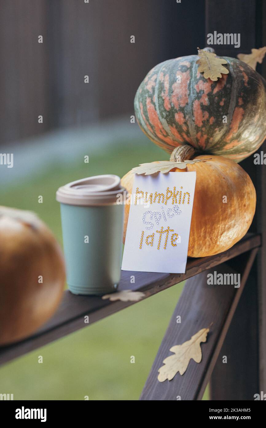 Caffè autunnale in una tazza con zucche e foglie di quercia, sullo sfondo della frase da rhinestones zucca spezia latte. Foto di alta qualità Foto Stock