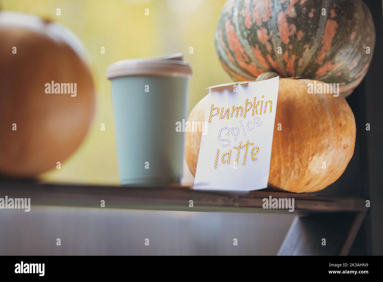 Caffè autunnale in una tazza con zucche e foglie di quercia, sullo sfondo della frase da rhinestones zucca spezia latte. Foto di alta qualità Foto Stock