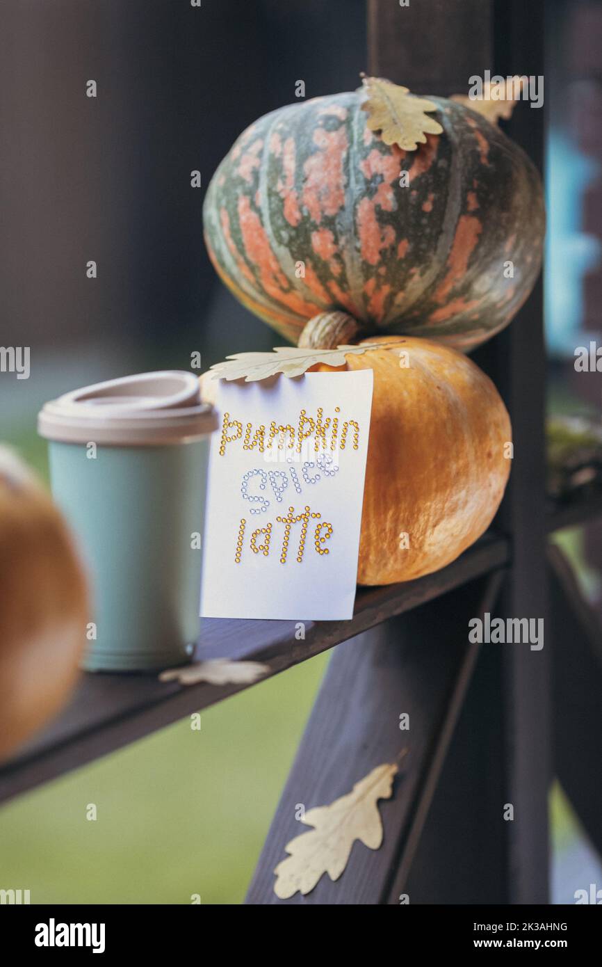 Caffè autunnale in una tazza con zucche e foglie di quercia, sullo sfondo della frase da rhinestones zucca spezia latte. Foto di alta qualità Foto Stock
