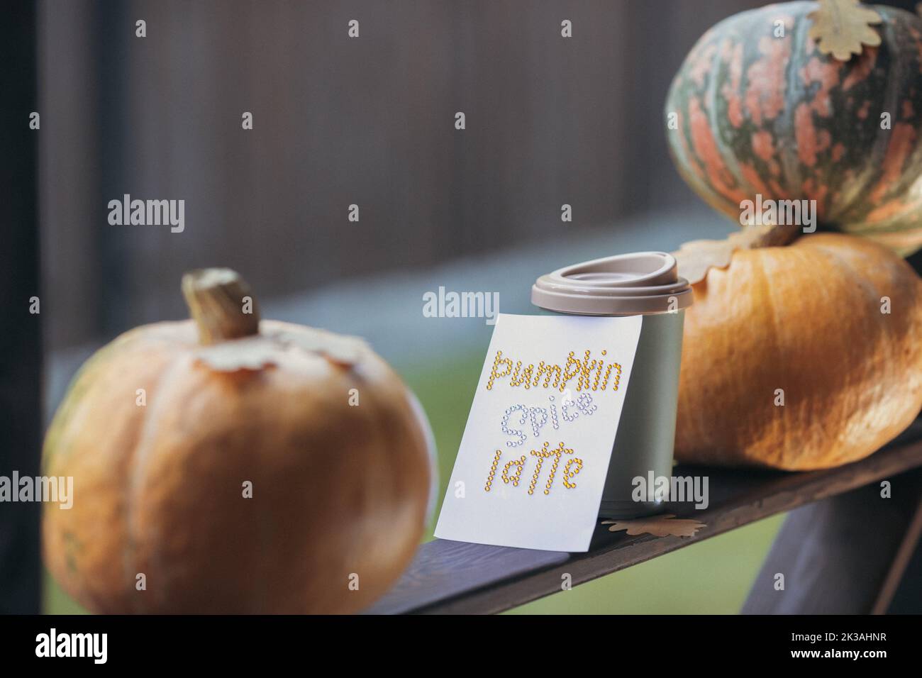 Caffè autunnale in una tazza con zucche e foglie di quercia, sullo sfondo della frase da rhinestones zucca spezia latte. Foto di alta qualità Foto Stock