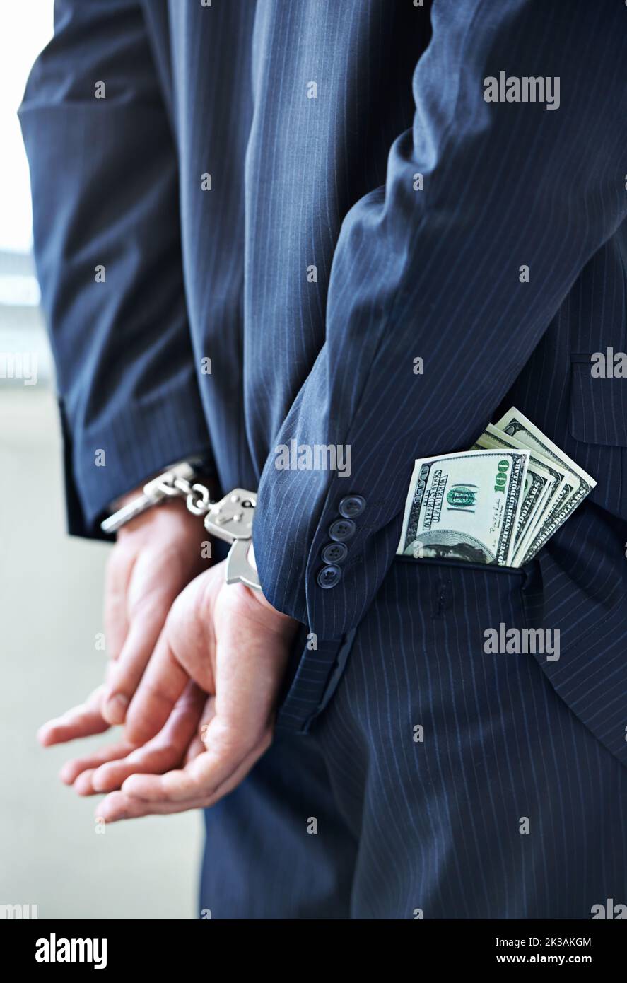 Pagherà per i suoi crimini, un uomo d'affari in manette con soldi in tasca. Foto Stock