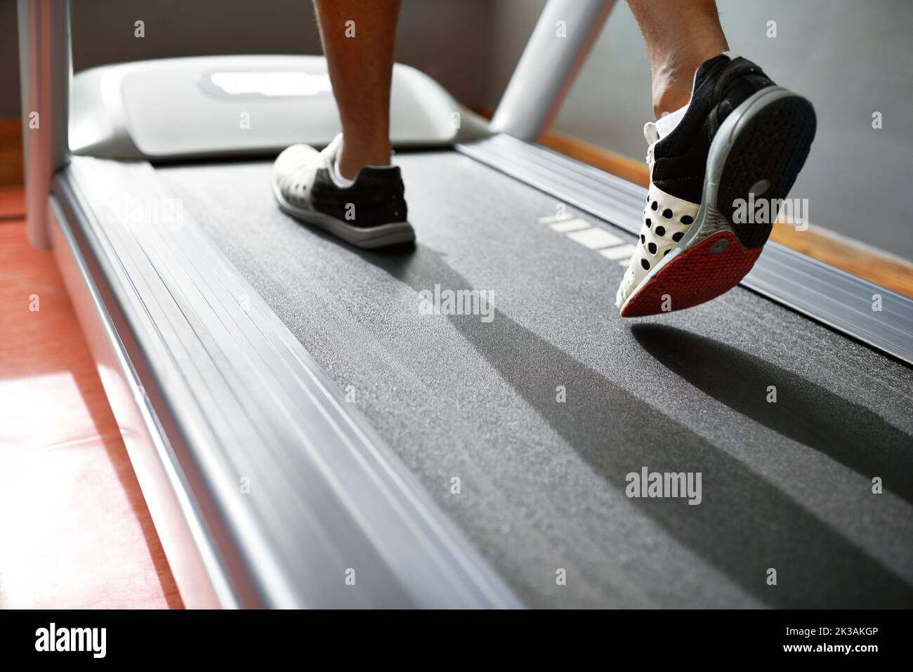 Bruciare calorie con un allenamento cardio. Colpo di primo piano di un uomo su un tapis roulant in palestra. Foto Stock