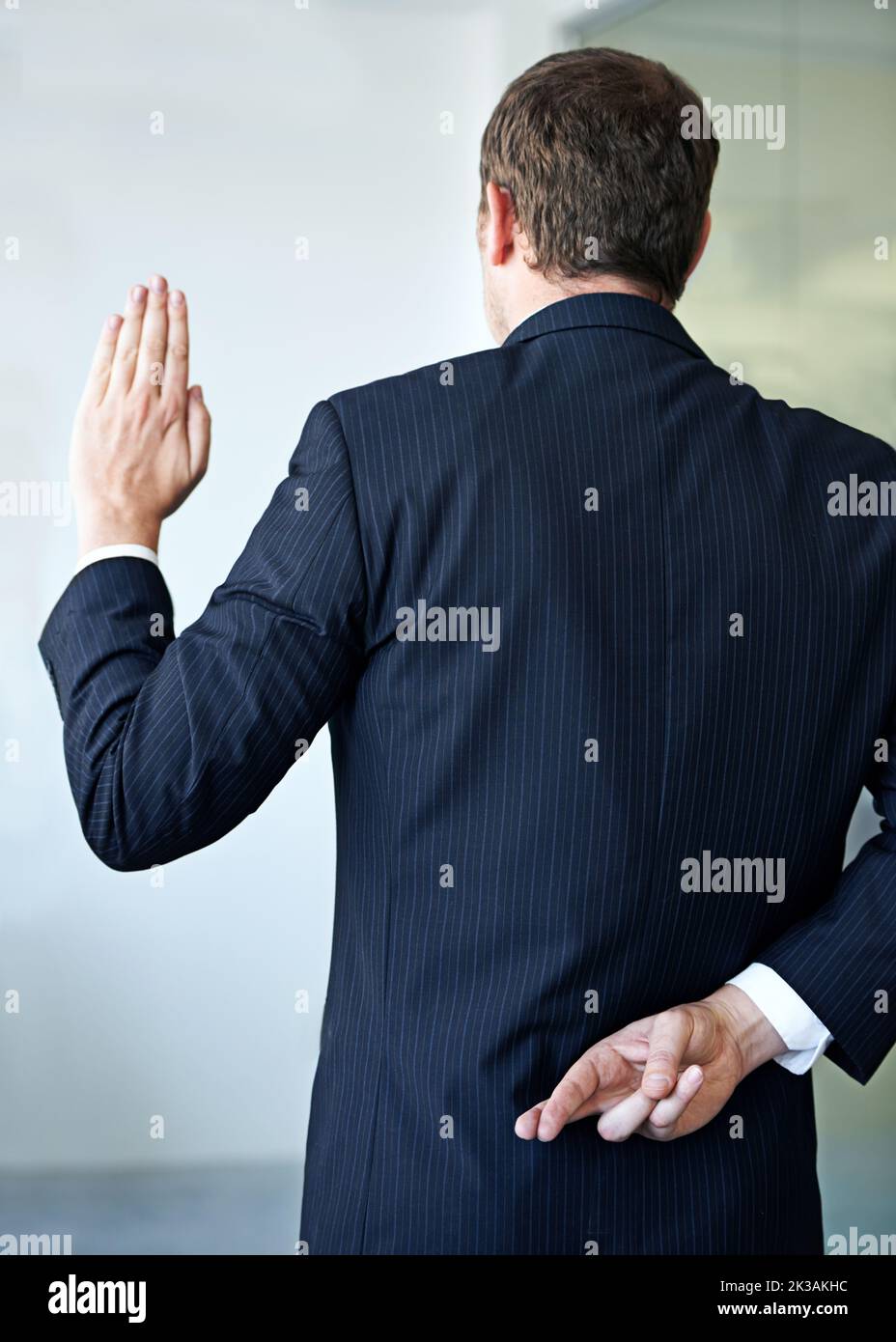 Pratiche commerciali non etiche. Un uomo d'affari che passa le dita dietro le spalle. Foto Stock