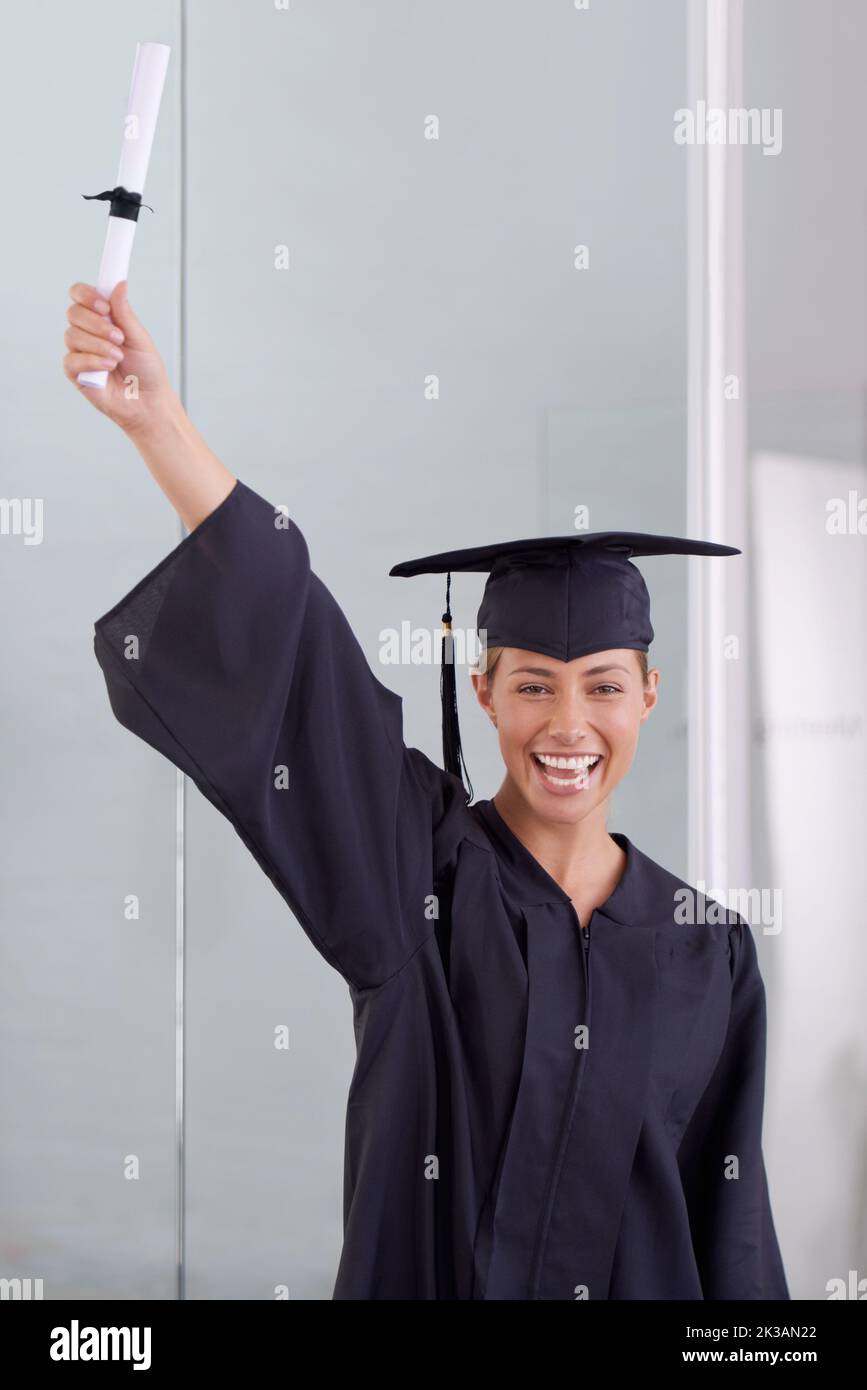 Il mondo è ora la sua ostrica, una giovane donna in un abito di laurea in possesso di un diploma. Foto Stock