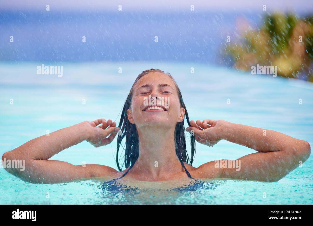 Raffreddamento dopo una giornata calda. Una bella giovane donna che si gode una nuotata. Foto Stock