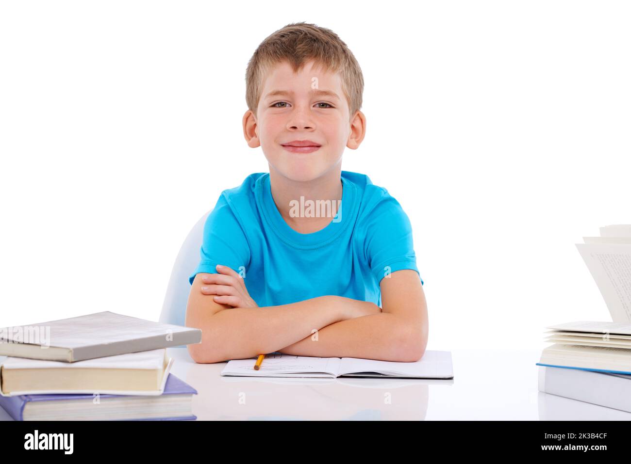 Mi piace studiare duro. Ritratto di un ragazzo sorridente seduto con pile di libri su sfondo bianco. Foto Stock