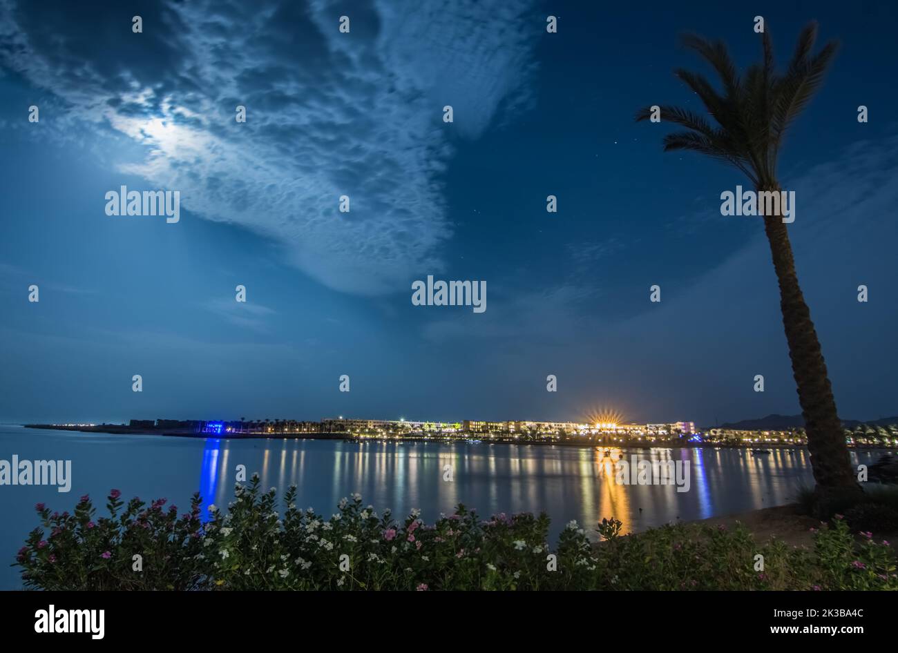 luci colorate da un resort sul mare con luna luminosa nella notte in egitto Foto Stock