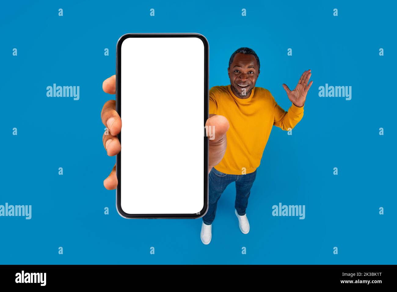 Stupito uomo nero maturo che mostra smartphone, beffa Foto Stock