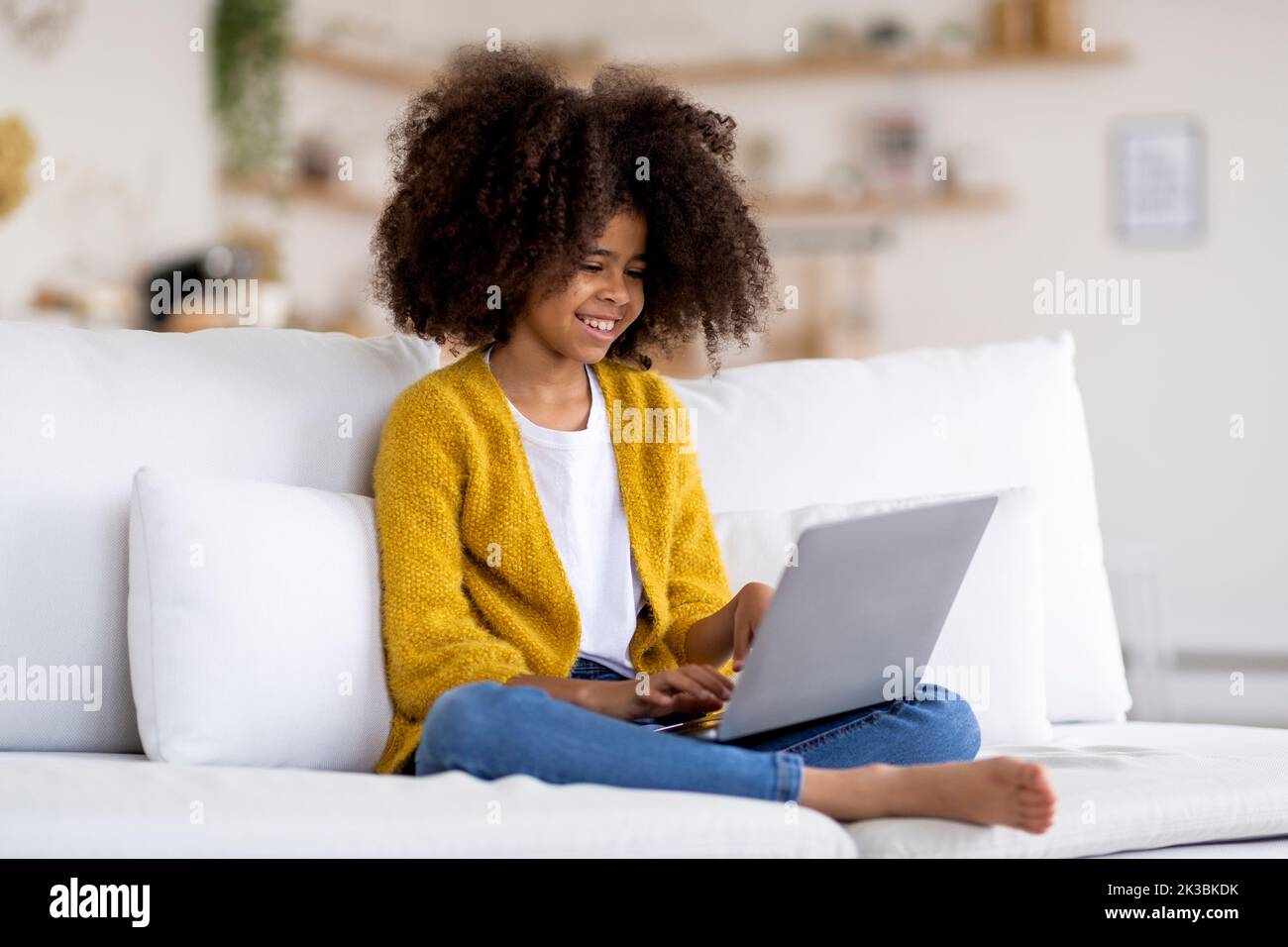 Felice bambino afroamericano che usa il laptop a casa Foto Stock
