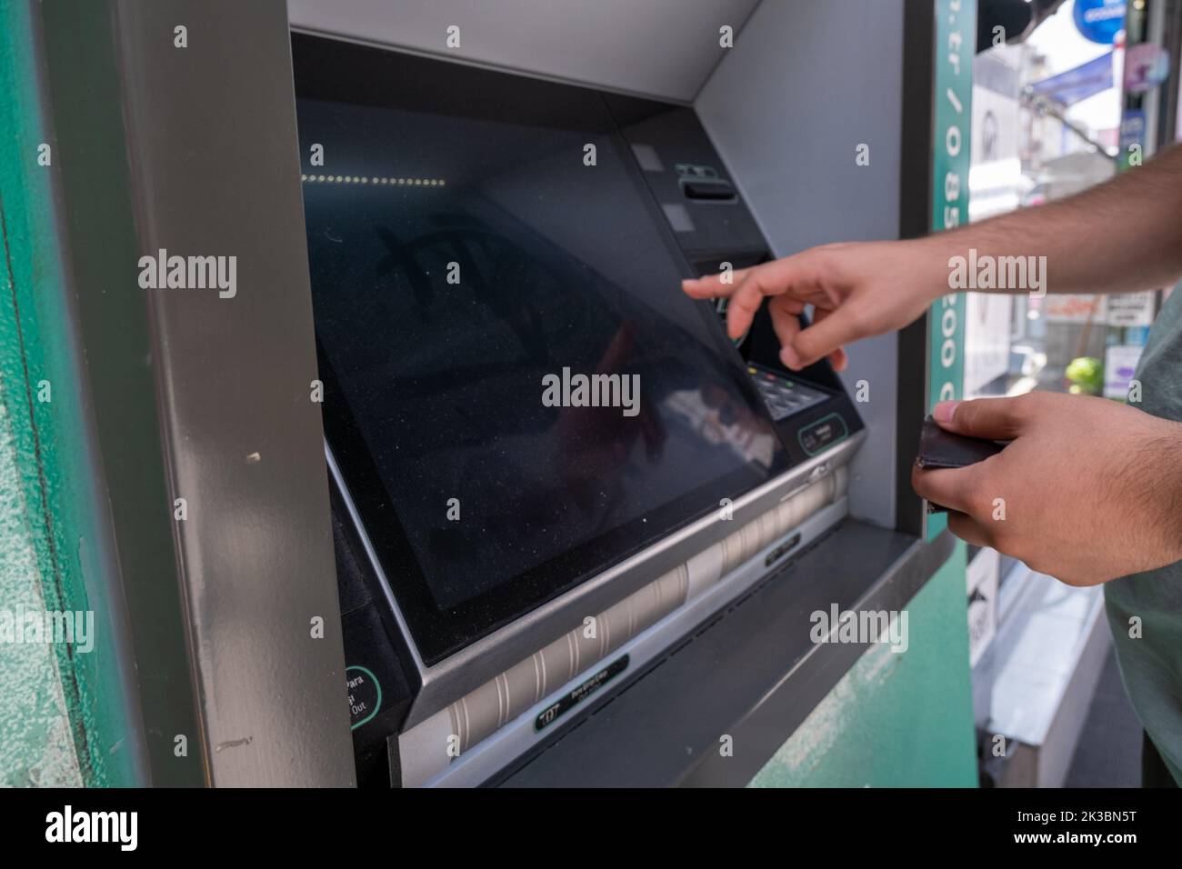 Mani uomo con bancomat, bancomat automatico con mano di persona, business e concetto bancario, bancomat con schermo, cliente che fa prelievo di denaro Foto Stock