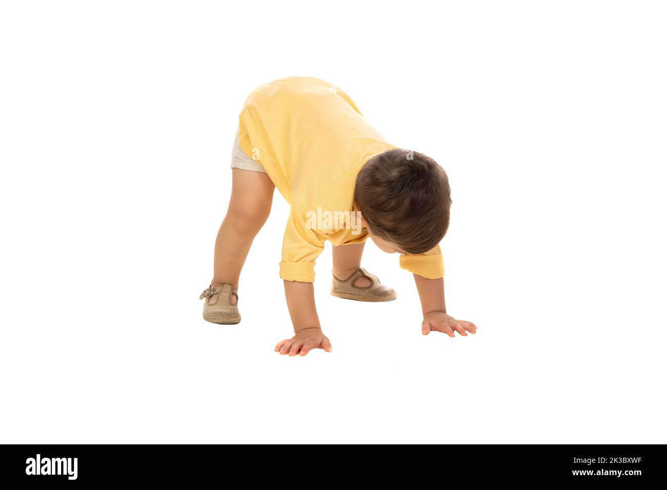 Cute bambino ragazzo cercando di alzarsi isolato su uno sfondo bianco Foto Stock