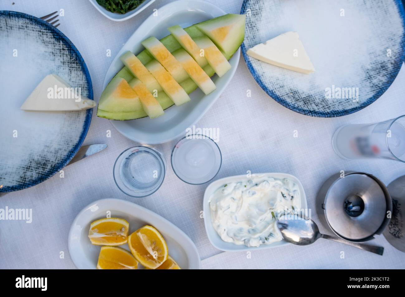 Tradizionale alcool turco conosciuto come Rakı, tavolo turco Raki con melone limone e antipasto, chill con gli amici al ristorante, cena e pasto idea Foto Stock