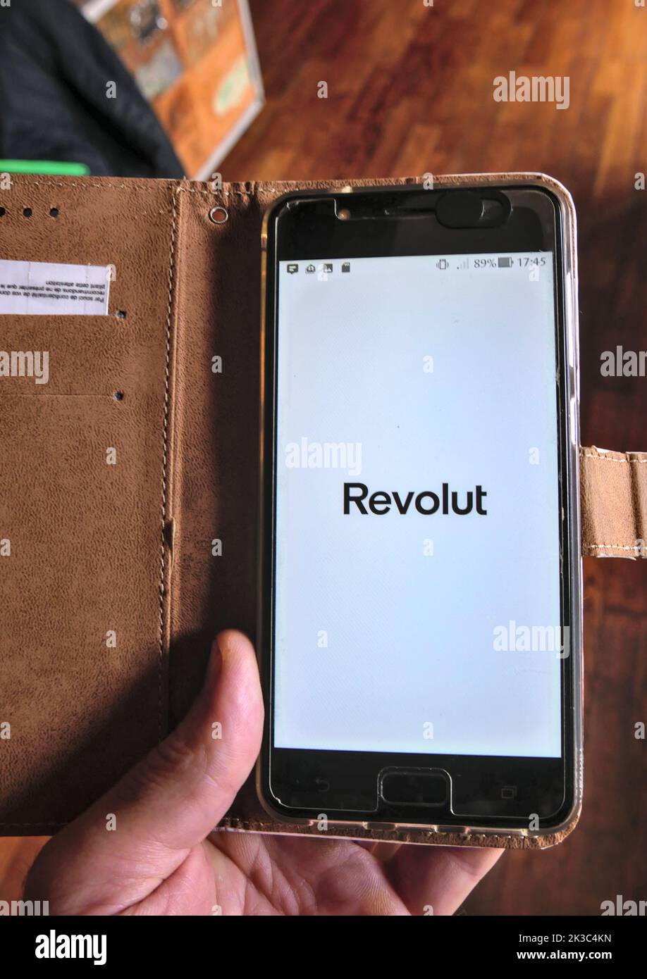 Smartphone aperto con Revolut banking app, tenuto da una mano maschio caucasica. Foto Stock