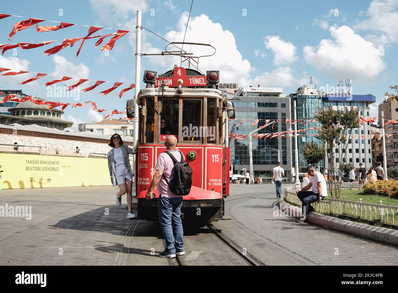 Persone che scattano foto in tram retrò Taksim, famoso treno rosso a Istanbul, viaggio e concetto di viaggio, giorno estivo soleggiato, paesaggio urbano in piazza Taksim Foto Stock