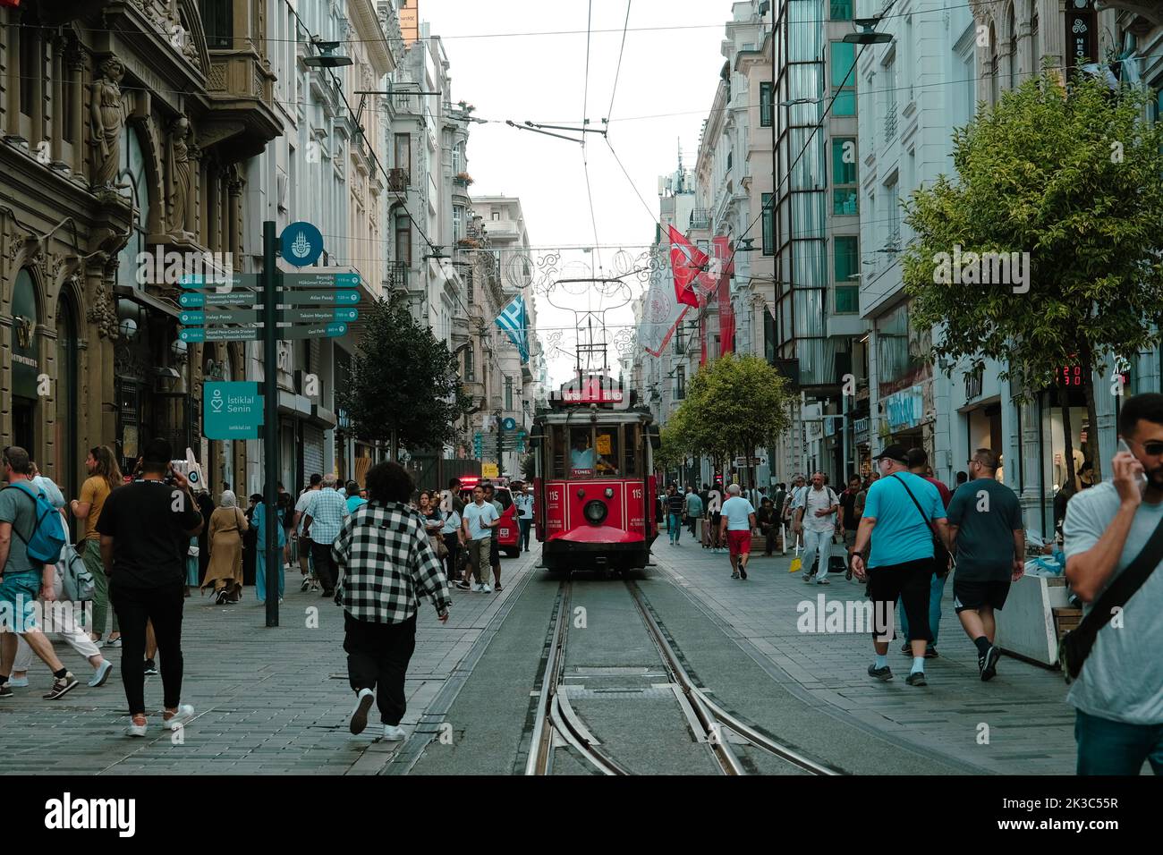Vista strada Istiklal con gente, paesaggio urbano a Istanbul, vista frontale del popolare tram rosso, strada retrò con persone a piedi, vecchio treno va in affollato Foto Stock