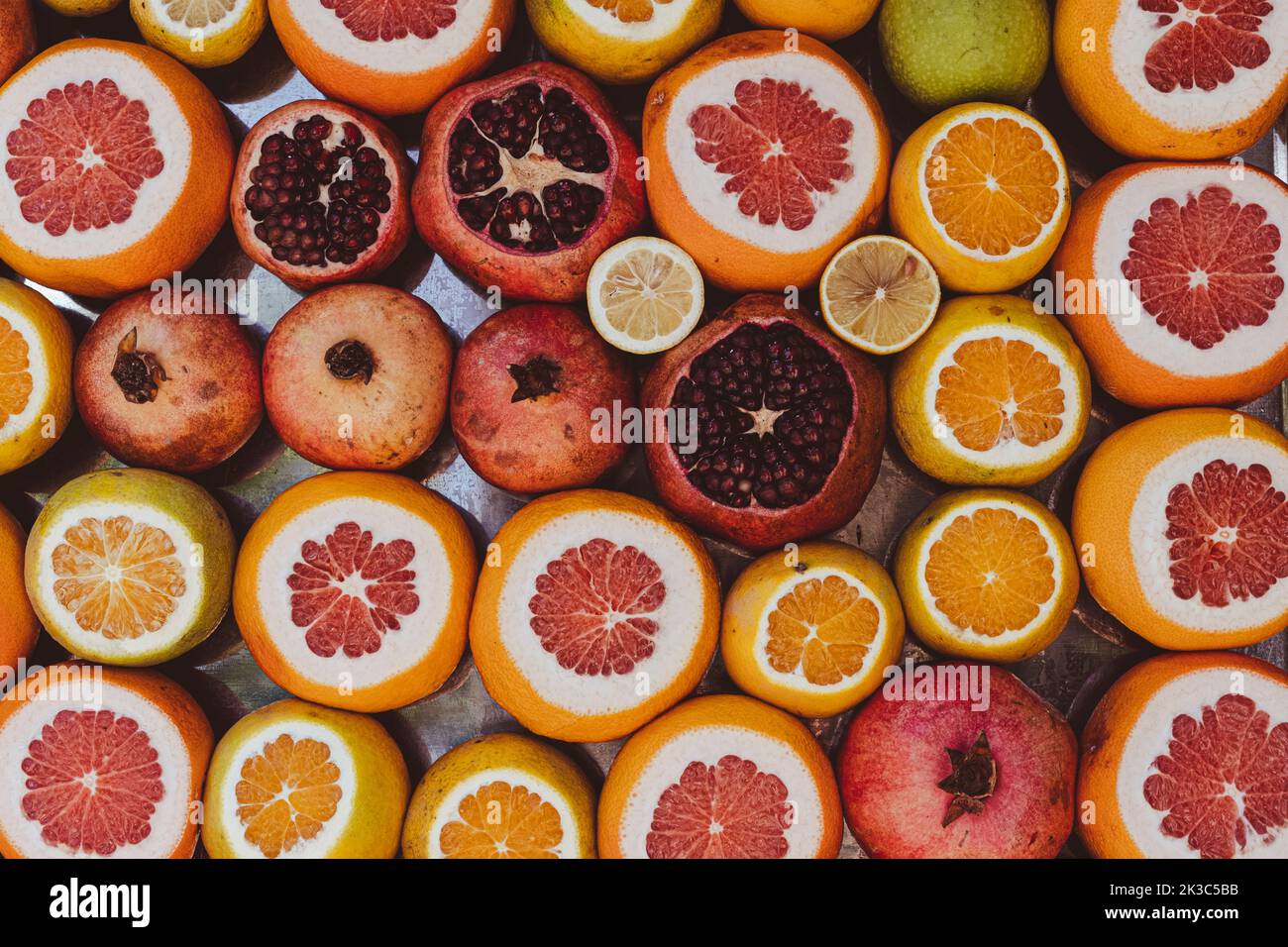 Tagliare melograno arancia pompelmo limone in stand mercato, carta da parati e sfondo alimentare, la vita sana e l'idea vegetariana Foto Stock