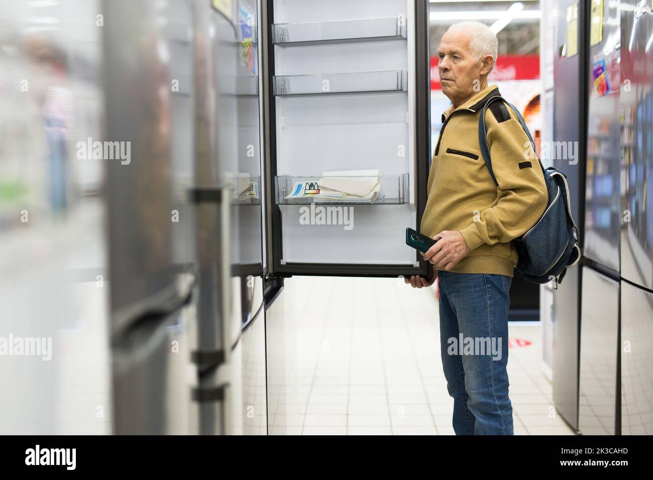 senor uomo pensionato acquistare frigorifero in showroom di elettrodomestici negozio Foto Stock