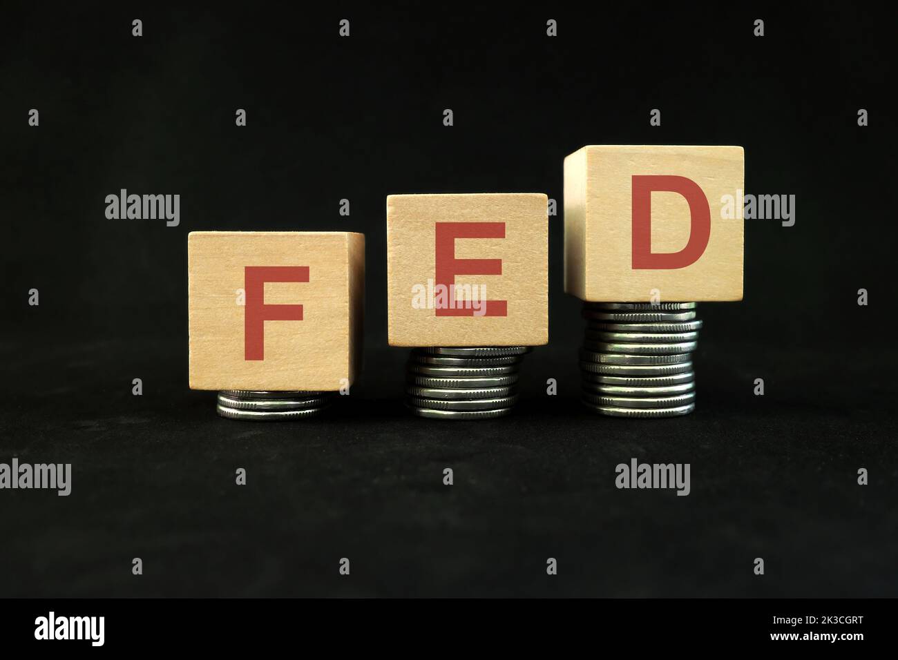 FED o Federal Reserve System aumento del tasso di interesse o concetto di aumento. Blocchi di legno su sfondo nero scuro. Foto Stock