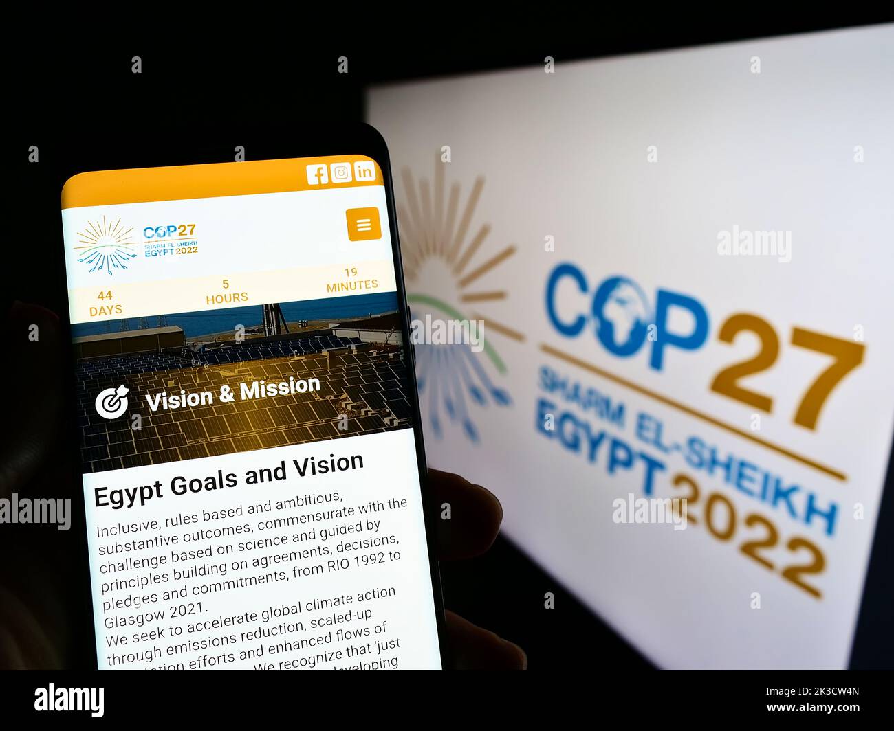 Persona che tiene il cellulare con il sito web di 2022 ONU Climate Change Conference (COP27) sullo schermo di fronte al logo. Messa a fuoco al centro del display del telefono. Foto Stock