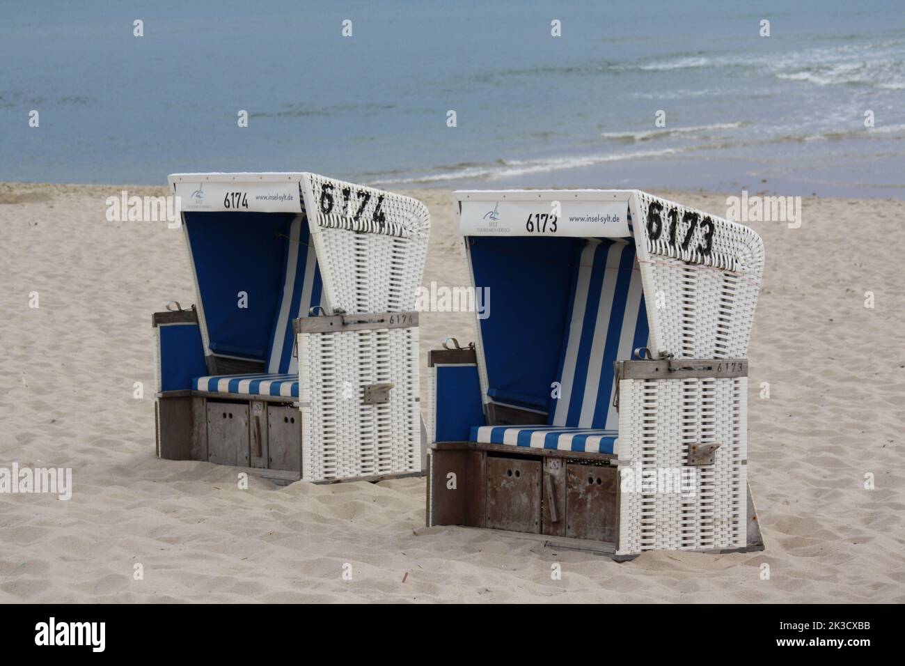Sedie in vimini con tetto blu e bianco sulla spiaggia di Rantum sull'isola di Sylt Foto Stock