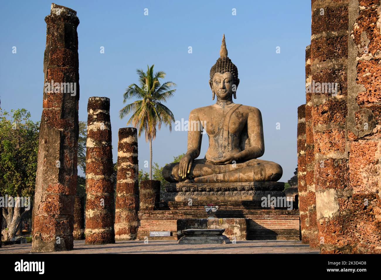 Statua del Buddha seduto all'alba nel tempio di Wat Mahathat, parco storico di Sukhothai, patrimonio dell'umanità dell'UNESCO, Thailandia settentrionale. Foto Stock