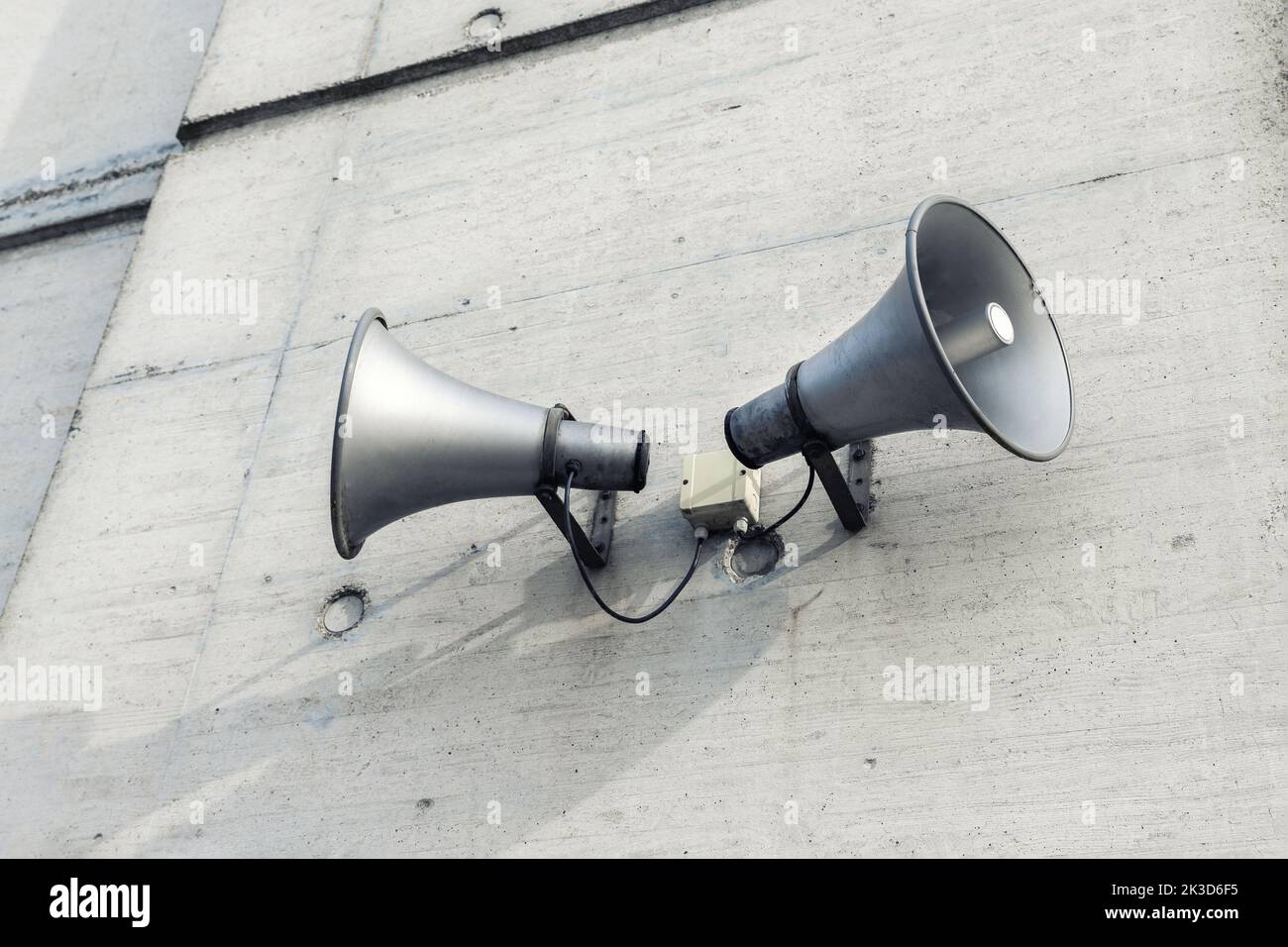 Coppia di grandi altoparlanti retrò montati su pareti in cemento grigio. Sirena di allarme per sciopero nucleare air raid. Annuncio urgente o di emergenza Foto Stock