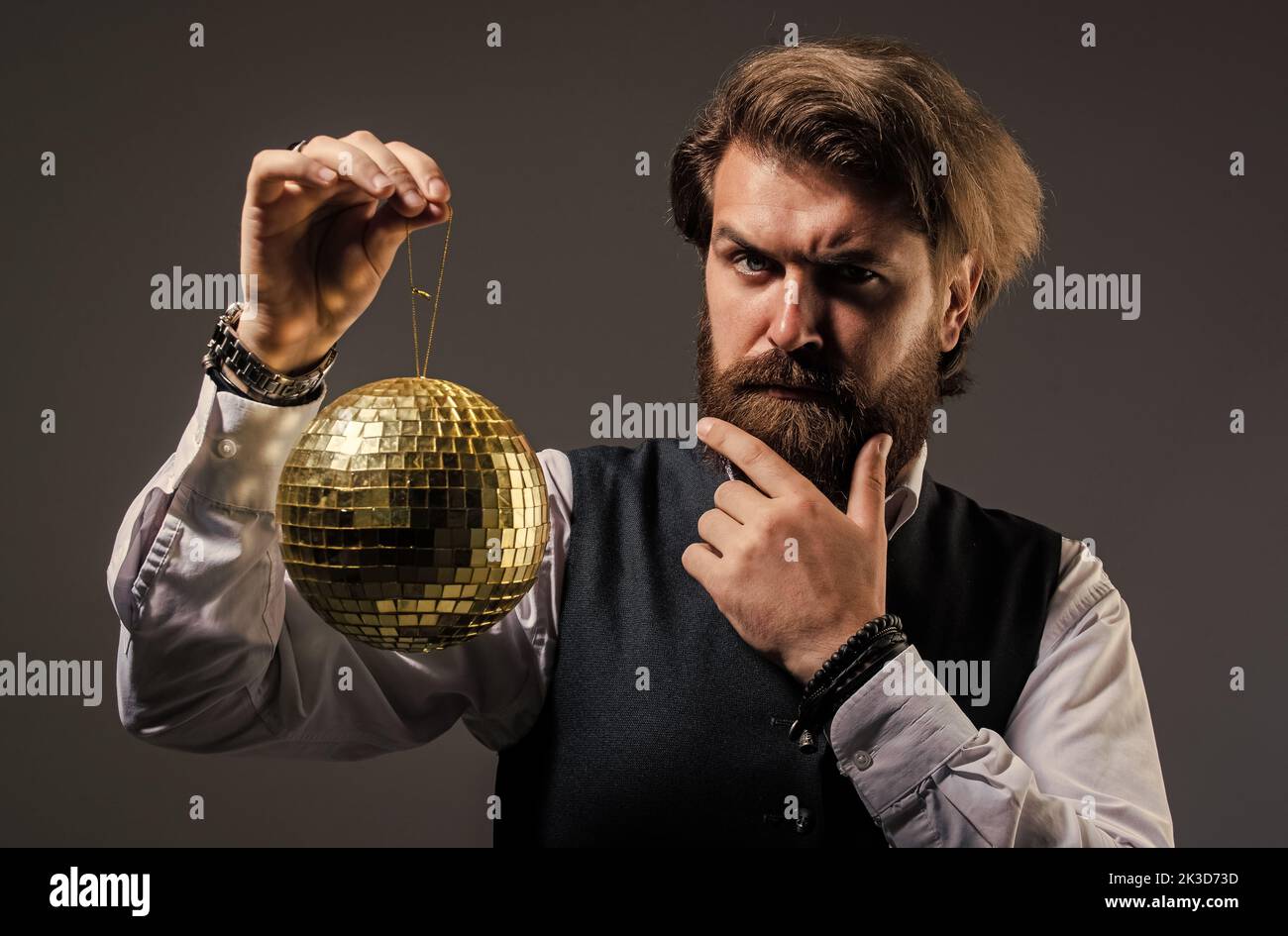 L'uomo maturo bearded tiene la sfera dorata della discoteca, concetto di invito della festa Foto Stock