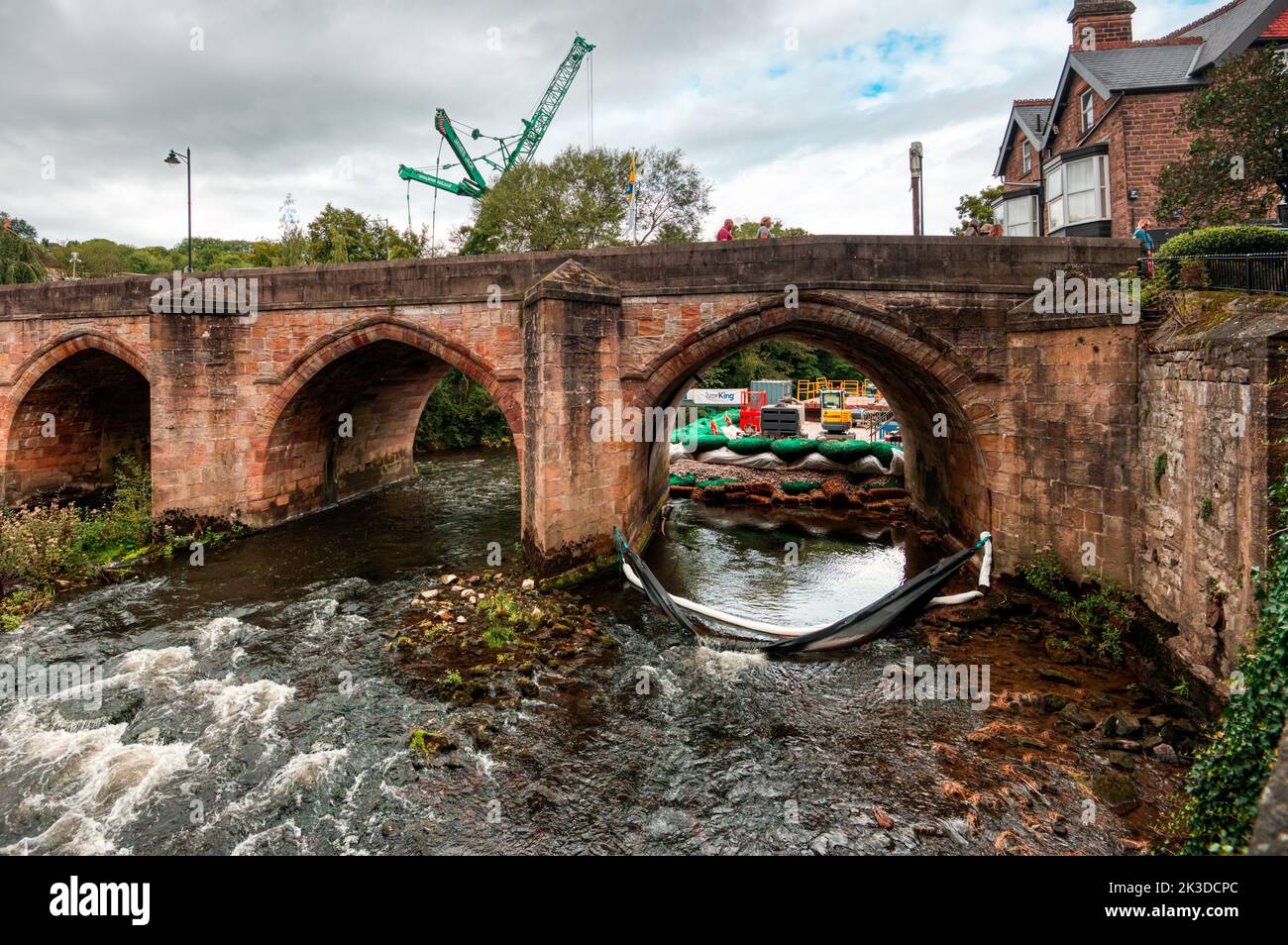 Riparazioni di prevenzione delle alluvioni con una gru gigante sulle rive del fiume Derwent a Matlock Bridge, Matlock, Derbyshire, Regno Unito Foto Stock