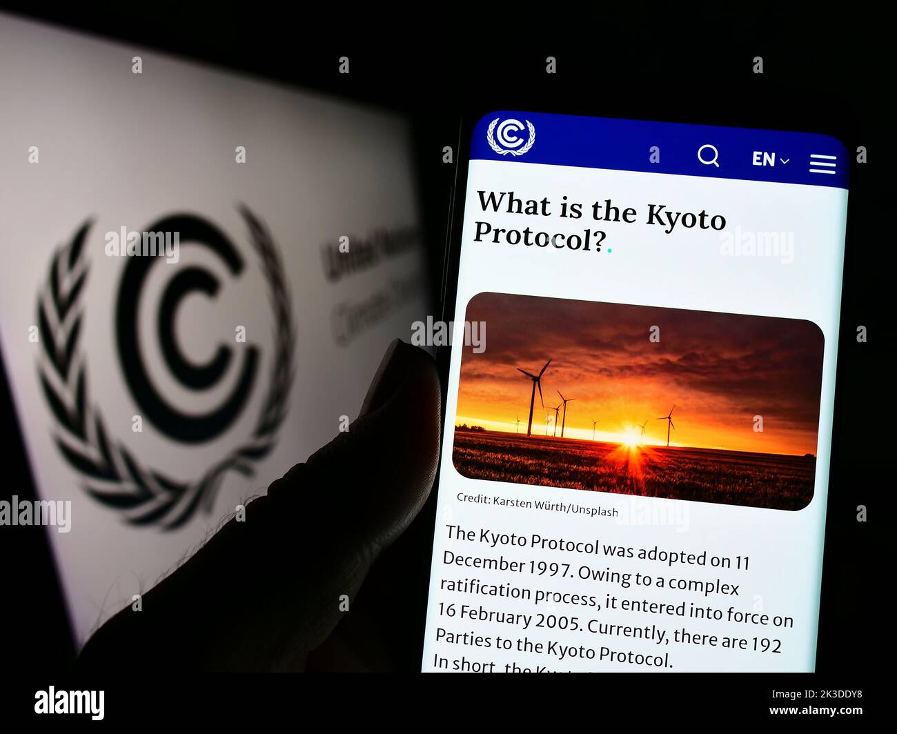 Persona che tiene in mano uno smartphone con il sito Web del trattato ambientale delle Nazioni Unite UNFCCC sullo schermo davanti al logo. Messa a fuoco al centro del display del telefono. Foto Stock