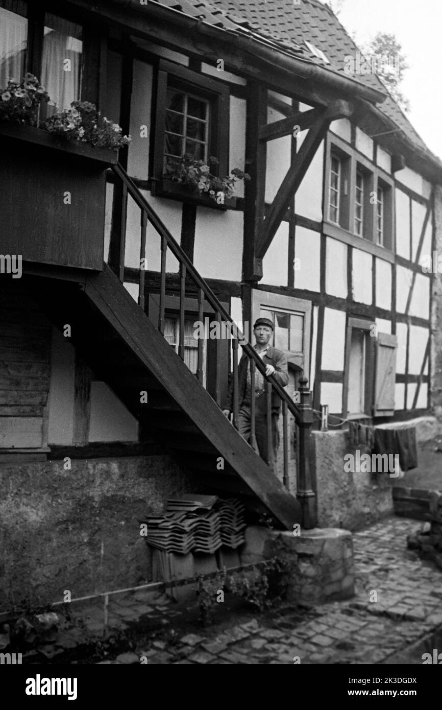 Mann auf Treppe in Kall in der Eifel, 1952. Uomo locale sulle scale a Kall, regione di Eifel, 1952. Foto Stock