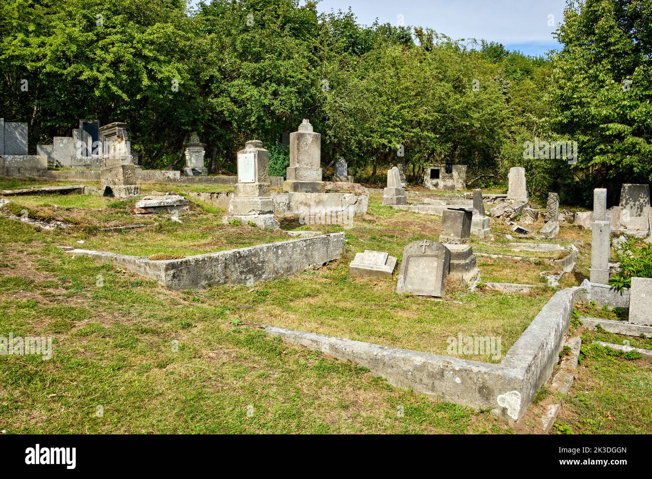 Terreno di sepoltura sovra e desolato nel cimitero fatiscente e abbandonato di Horni Krupka vicino alla torre panoramica di Komari vizka, Repubblica Ceca. Foto Stock