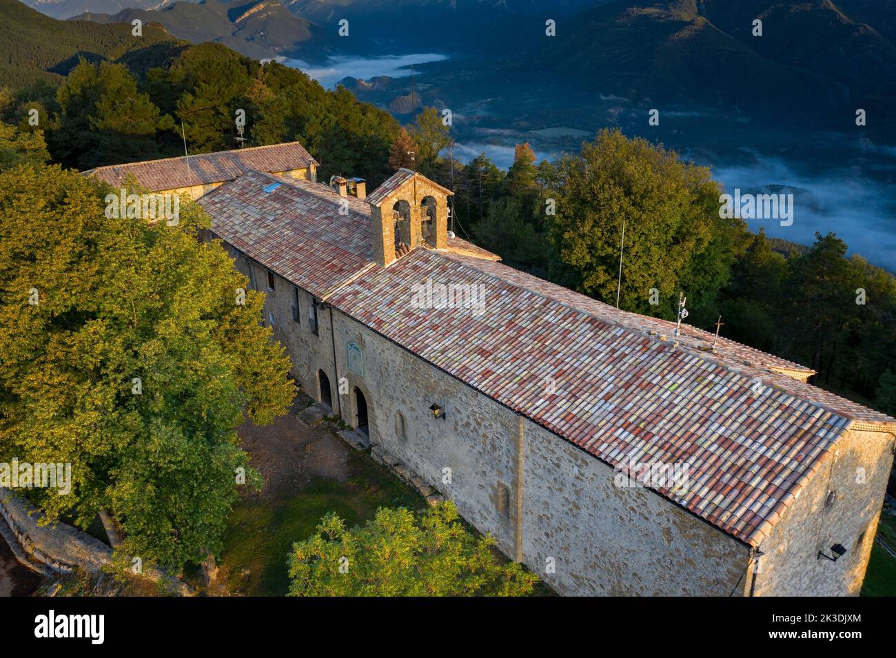 Veduta aerea del santuario Falgars e della catena montuosa di Catllaràs all'alba con nebbia nella valle di Lillet (Berguedà, Barcellona, Catalogna, Spagna) Foto Stock