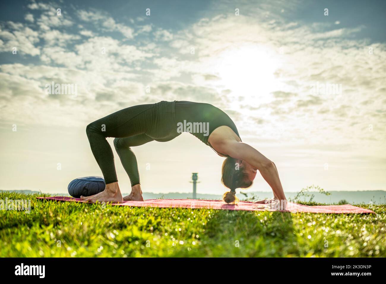 Yoga, donna, alba, posa del ponte, energetico, profondo, cura di sé, a piedi nudi, forza, equilibrio, stile di vita sano, sollievo dallo stress, consapevolezza, flessibilità Foto Stock
