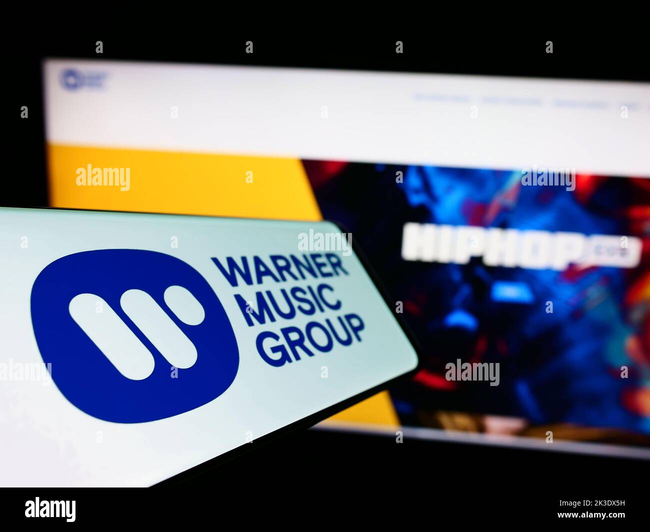 Smartphone con il logo della società di intrattenimento Warner Music Group Corp. Sullo schermo di fronte al sito Web aziendale. Messa a fuoco a sinistra del display del telefono. Foto Stock