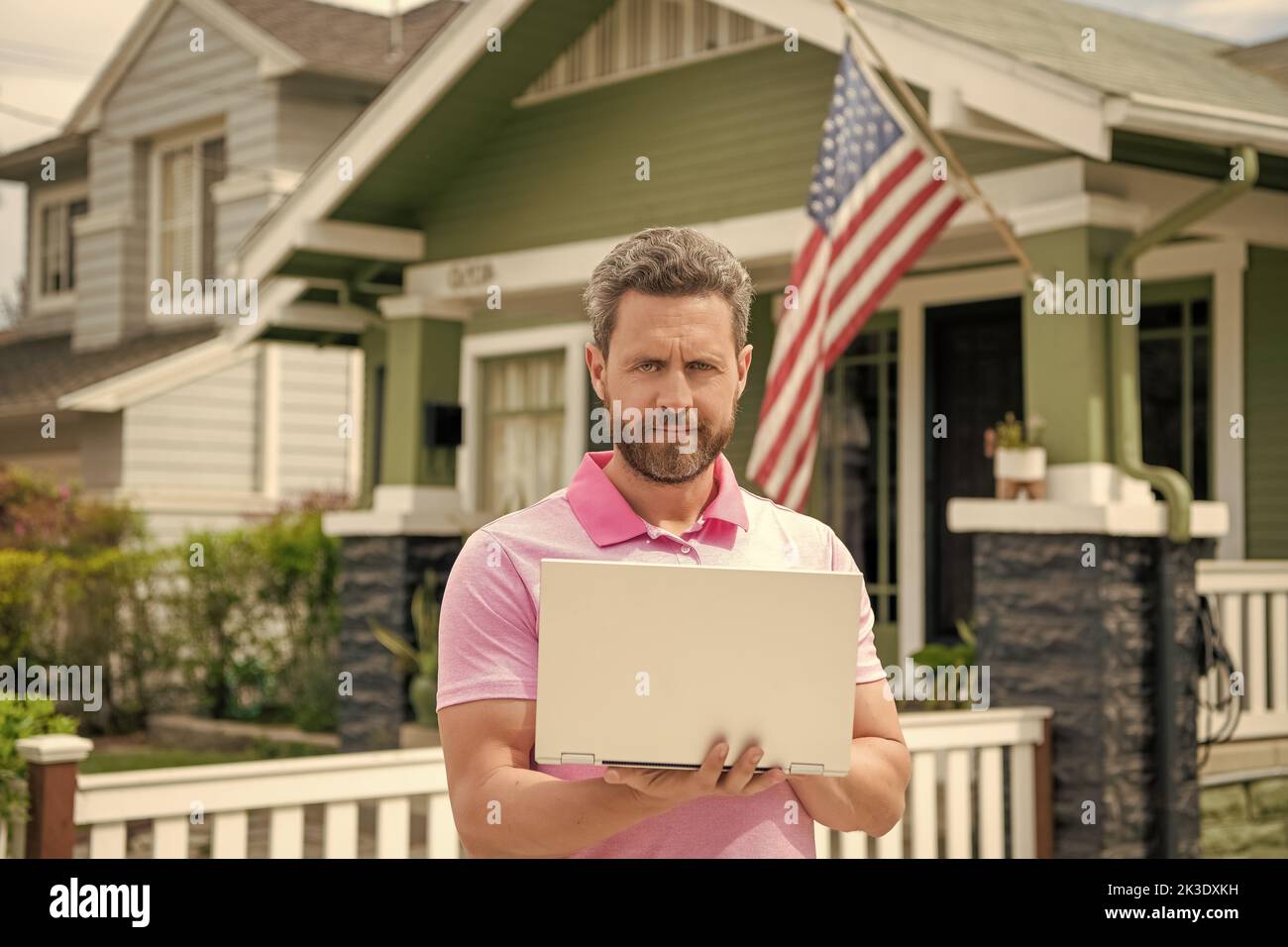 uomo bearded realtor che compra casa in linea sul laptop, proprietà Foto Stock