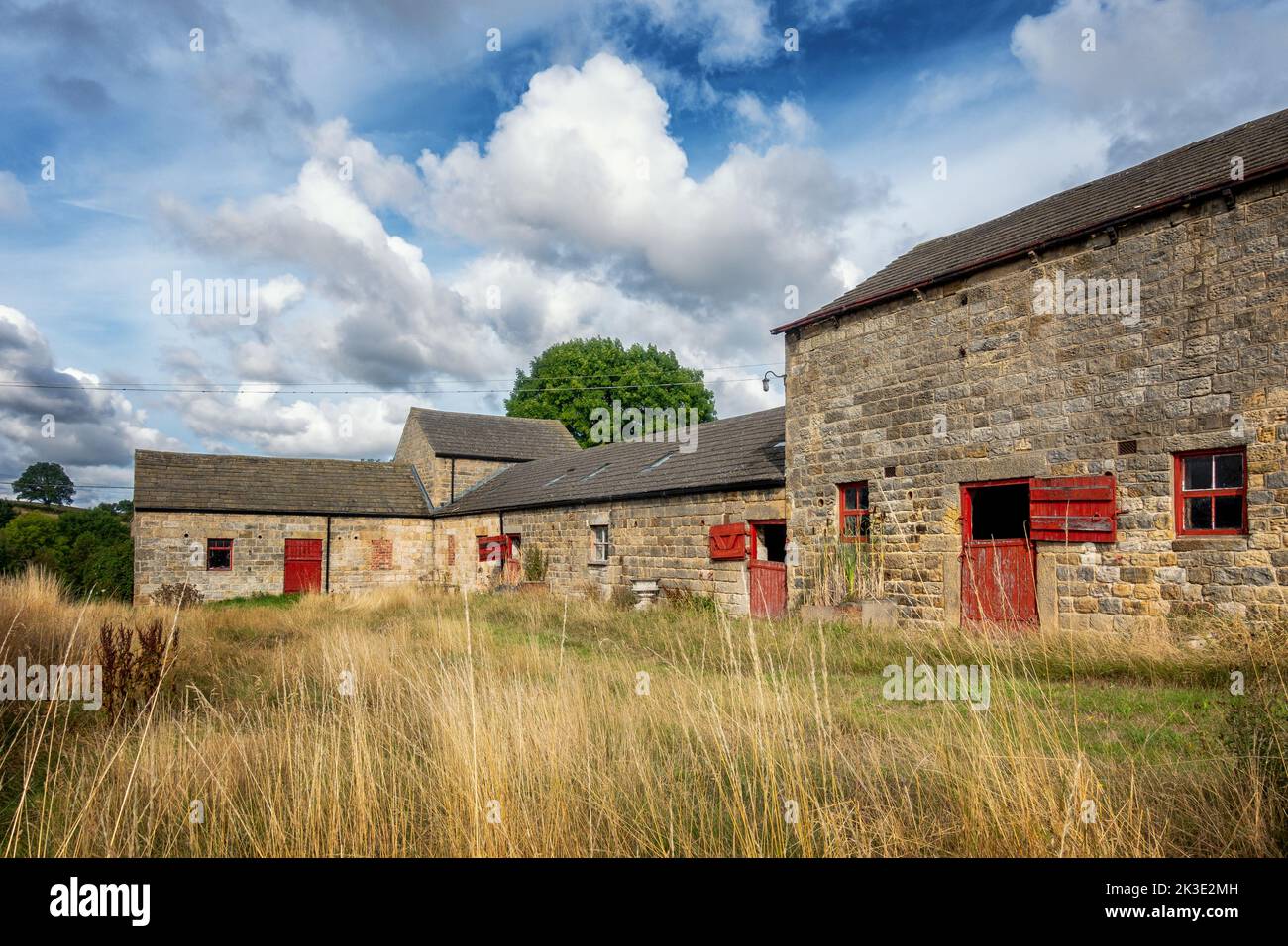 Splendidi vecchi fienili con legno rosso abbinato alle finestre e alle porte del fienile, North Yorkshire, Inghilterra, Regno Unito Foto Stock