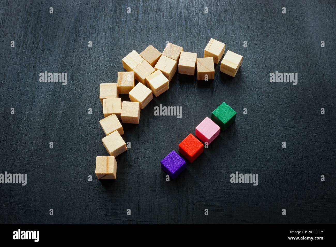 Cubi colorati e legno intorno a loro. Concetto di equità e inclusione nella diversità. Foto Stock