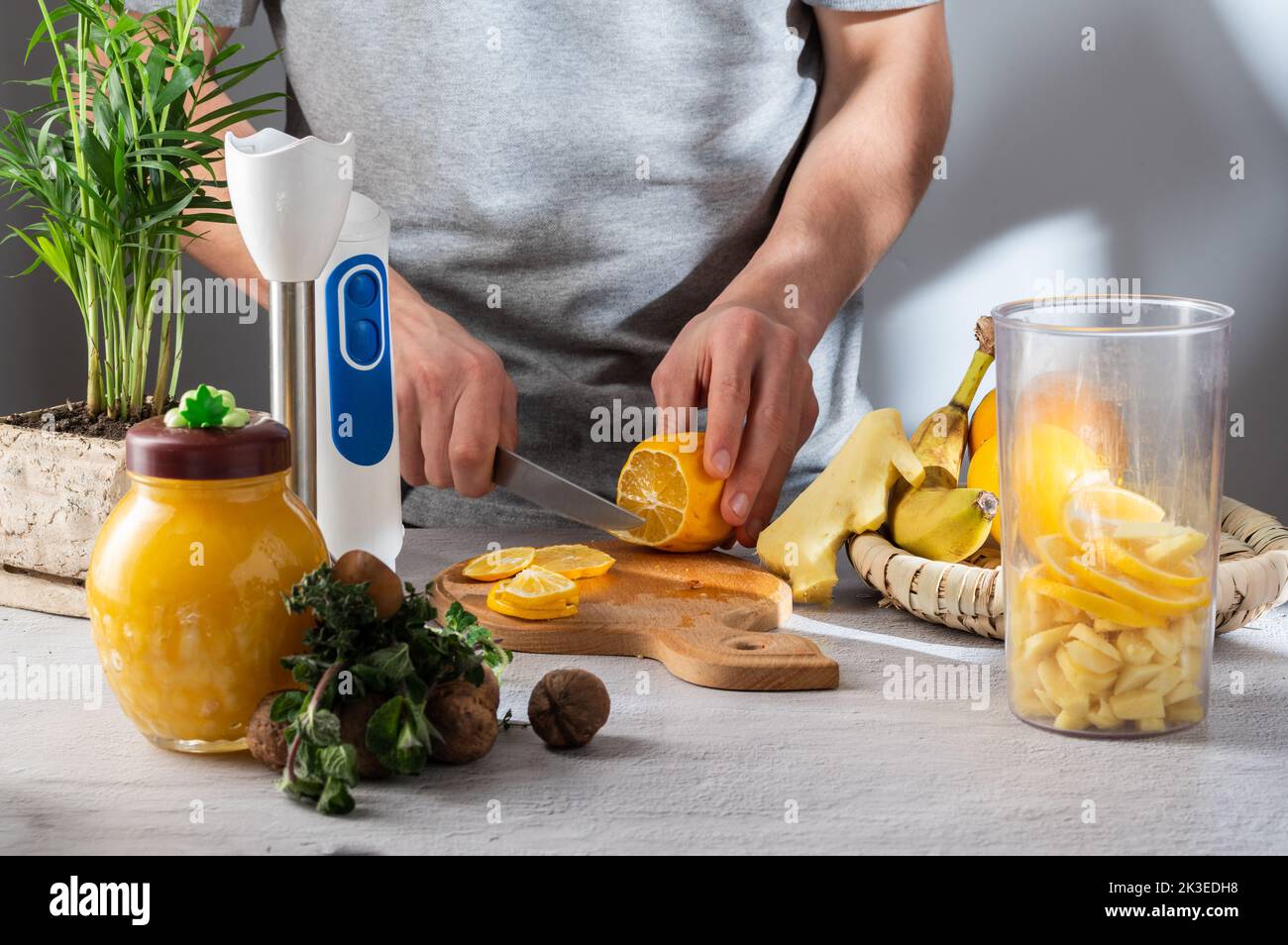 Tagliare il limone a fette. Coltello e fettine di limone. Preparazione della medicina a partire da limone, zenzero e miele. Vista frontale. Foto Stock