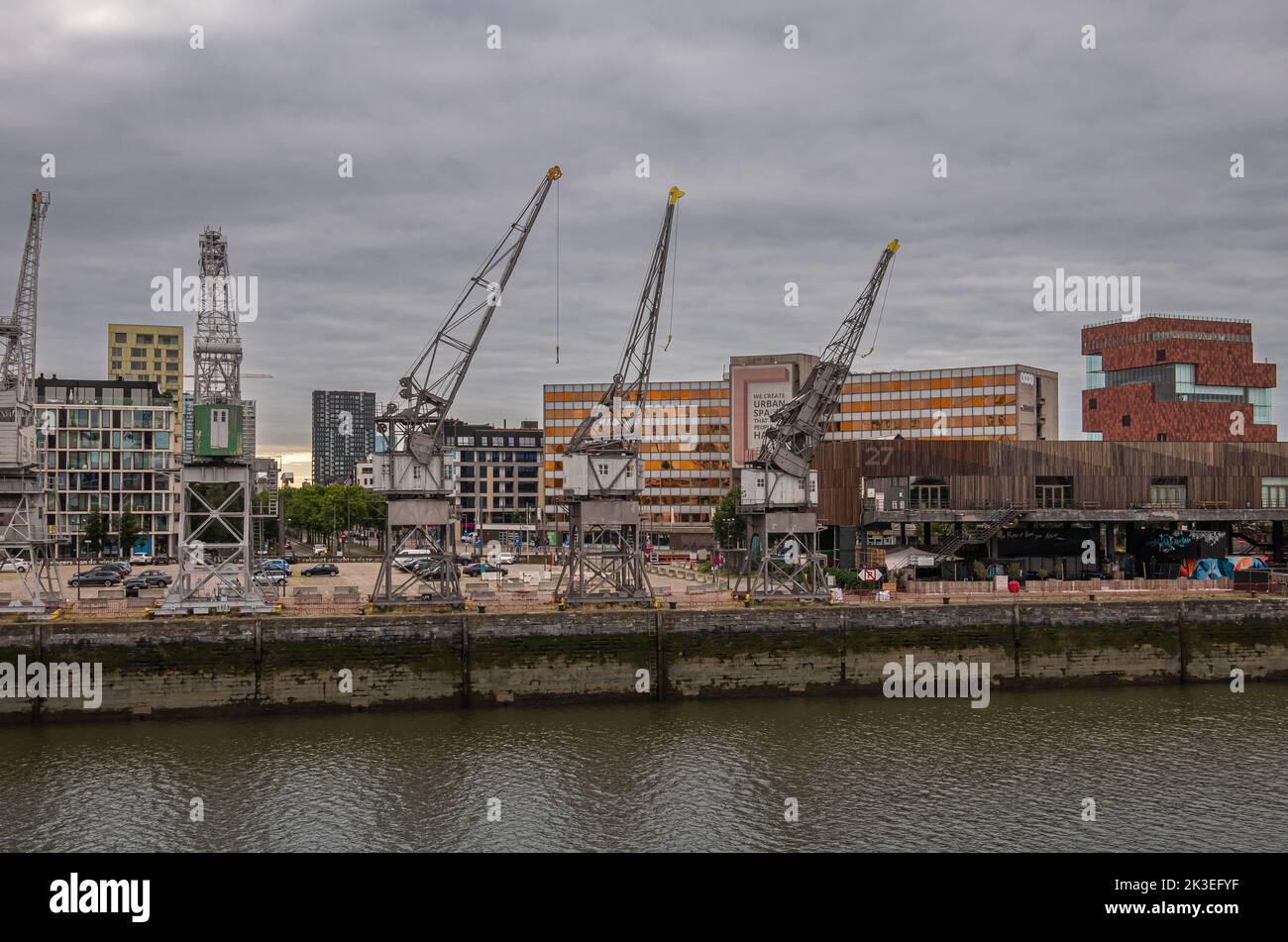 Anversa, Fiandre, Belgio - 10 luglio 2022: Lungo la banchina del fiume Scheldt. Moderno edificio di amicizia e Museo del Patrimonio Rosso dietro il gruppo del po storico Foto Stock