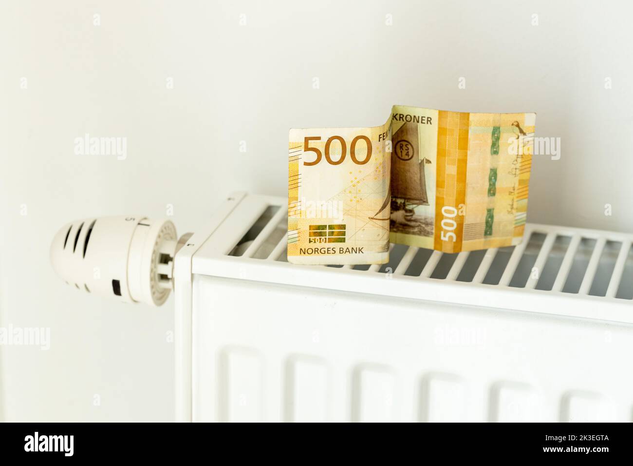 500 banconota NOK posta sul radiatore, il concetto di aumento dei prezzi dell'energia in Norvegia e di riscaldamento più costoso Foto Stock
