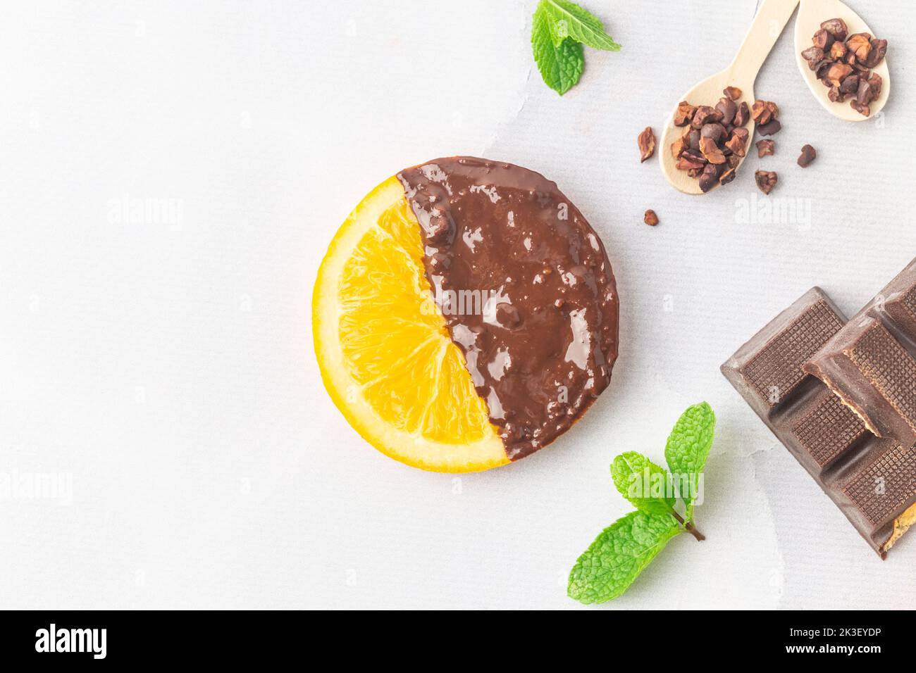 Fare fette di arancia candita immerse in flatlay di cioccolato fondente Foto Stock