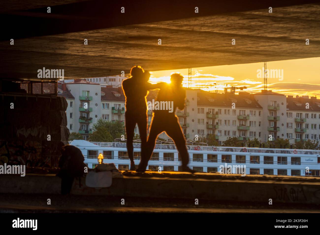 Wien, Vienna: Sport di pugilato da 2 uomini sotto il ponte Reichsbrücke, tramonto, nave da crociera nel 22. Donaustadt, Wien, Austria Foto Stock