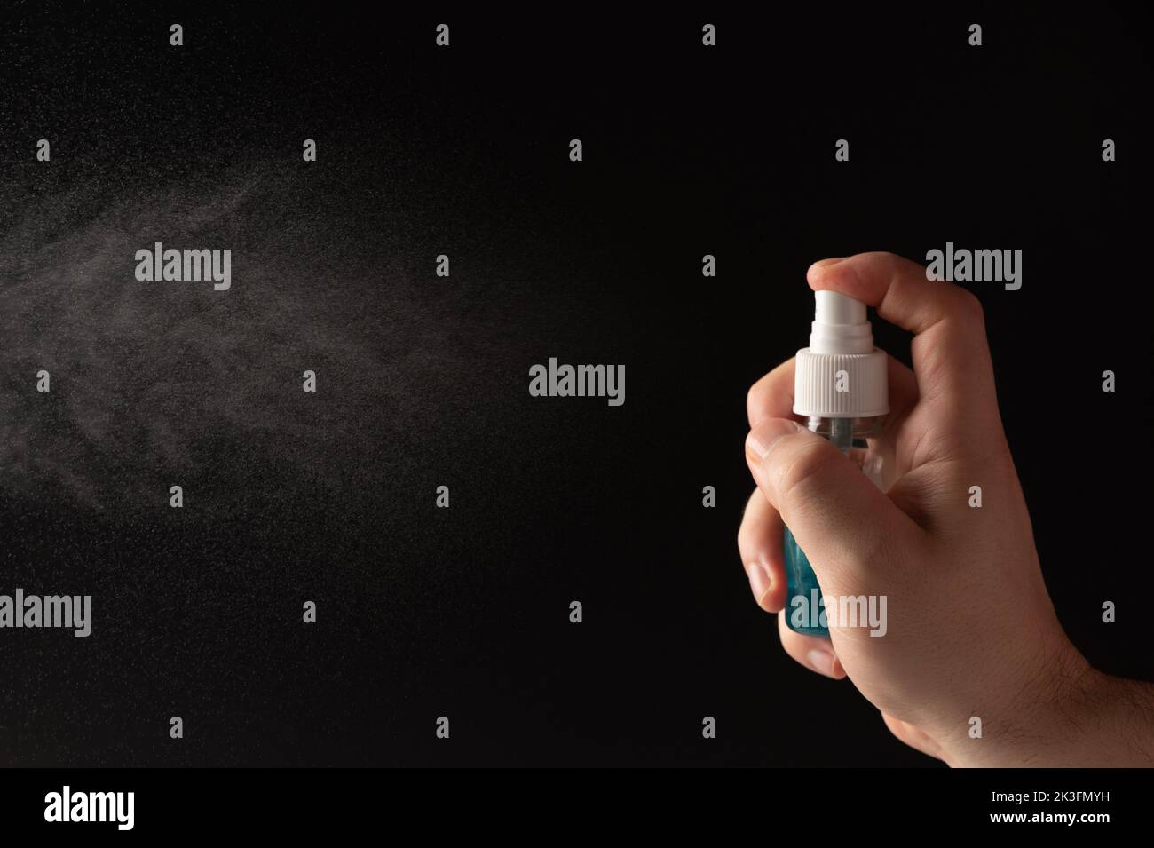 Spray blu per mani per uso orale isolato su sfondo nero Foto Stock