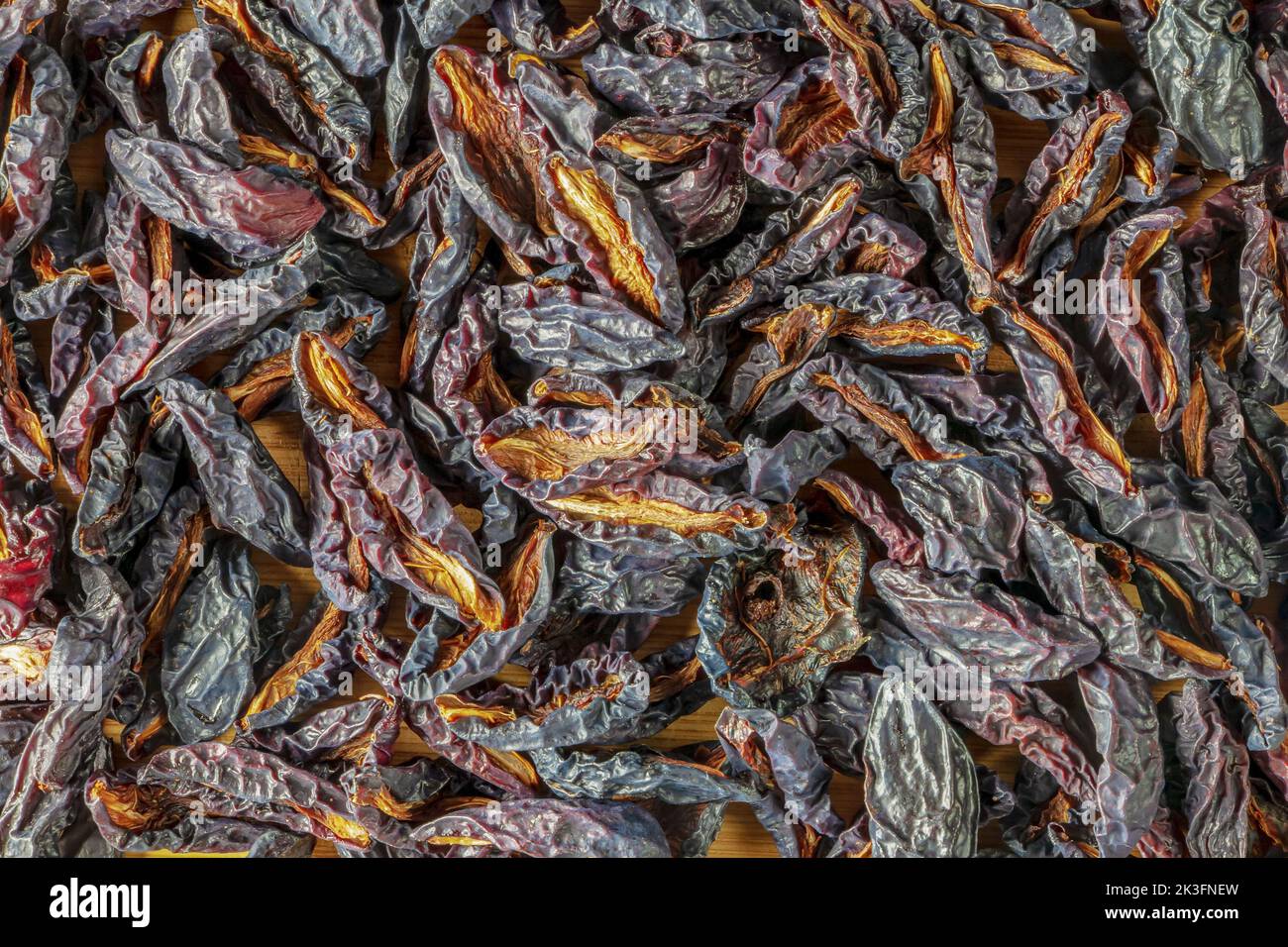 Sfondo di fette di prugne nere essiccate. Patatine di frutta secca. Cibo sano. Vista dall'alto. Foto Stock