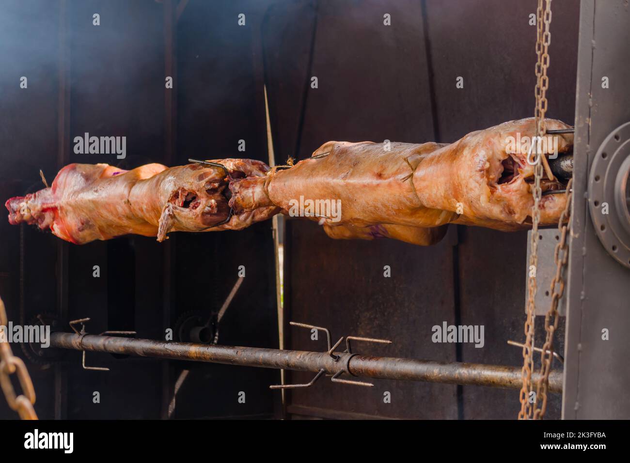 Processo di cottura delle carcasse di ariete su spit al mercato di Street food estivo: Primo piano Foto Stock